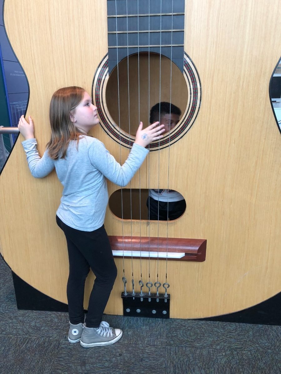 Things to do Seattle with kids - Playing with the giant guitar at Seattle's Pacific Science Center